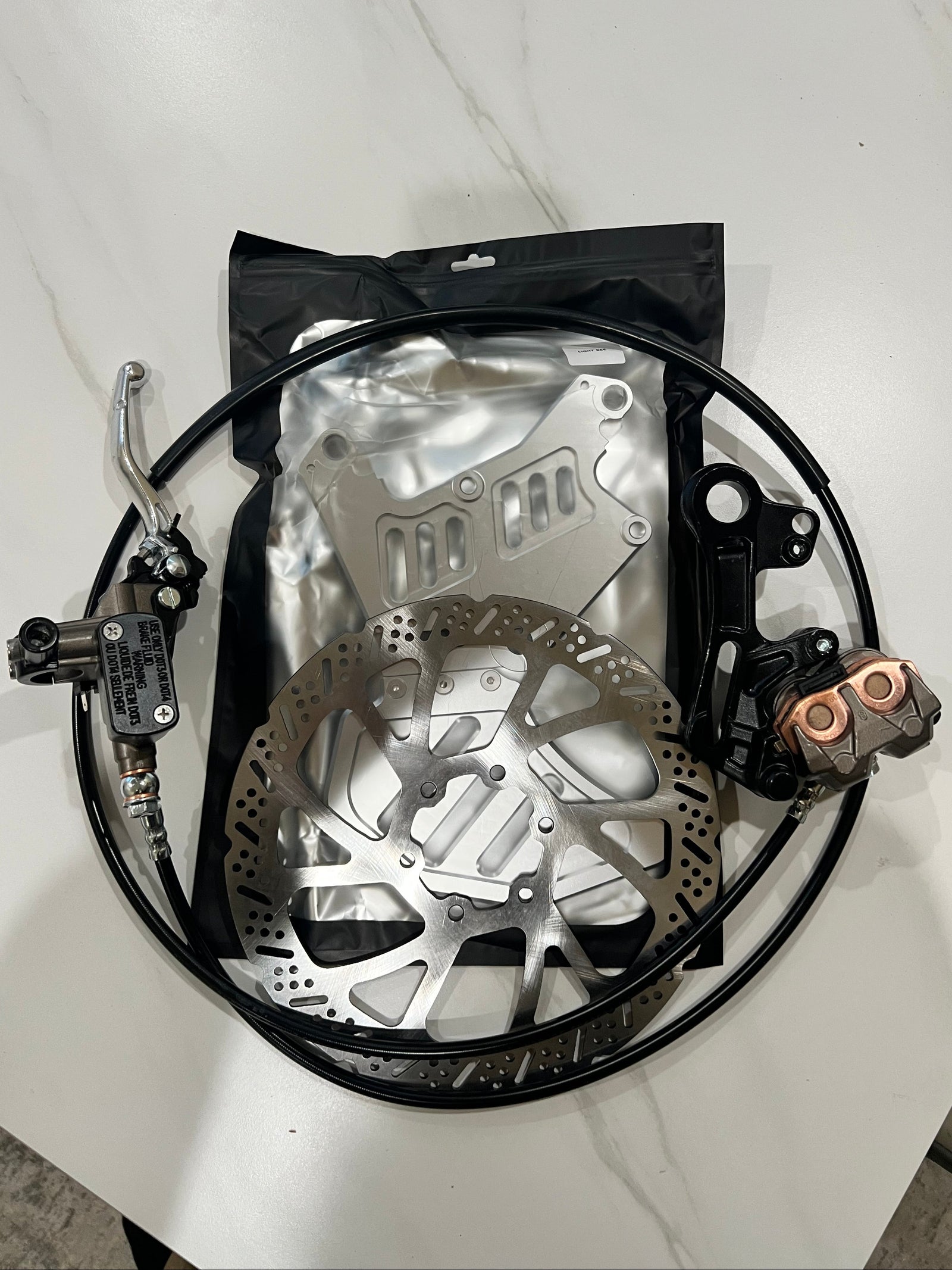 Silver Surron dual-caliper brake mount rear view