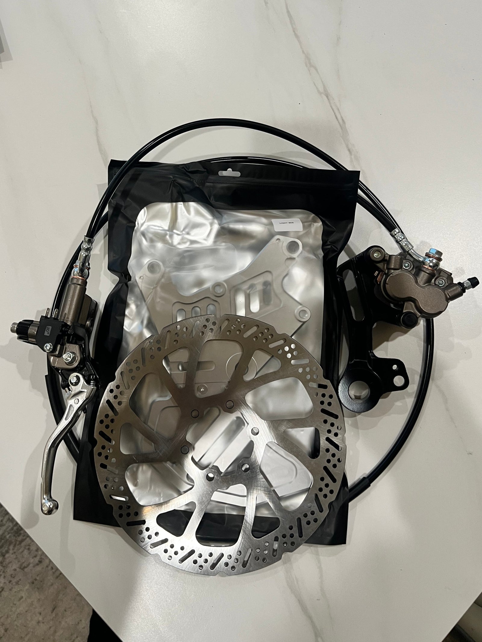 Silver Surron dual-caliper brake mount front view